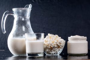 Pitcher and glass of milk, bowl of shredded cheese, jar of cream cheese